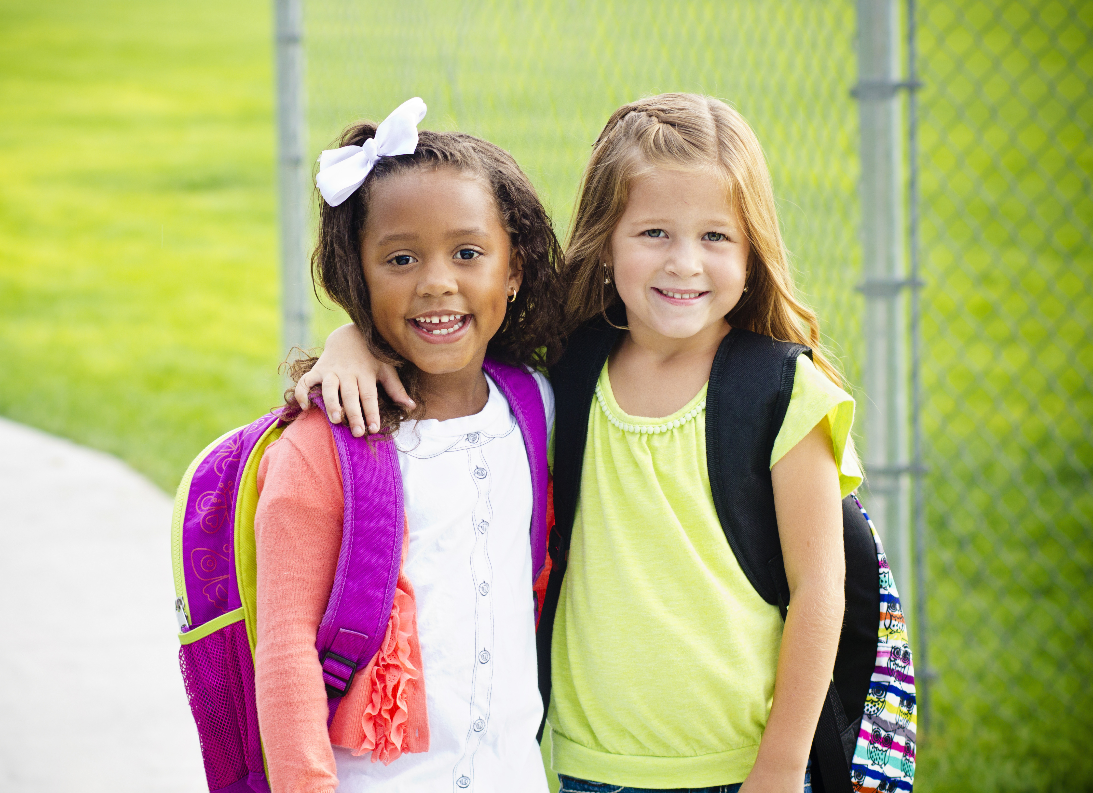 Two young student girls with their arms around each other